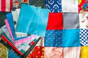 Most Popular Types of Quilting - The Creative Folk Stack of patchwork quilt squares in mixed prints